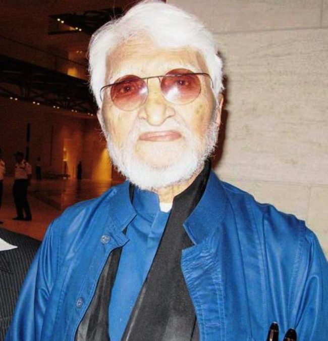 M. F. Husain with white hair and beard, wearing glasses