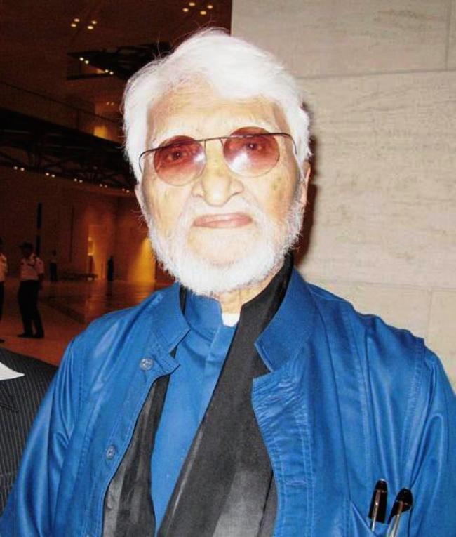 M. F. Husain with white hair and beard, wearing glasses