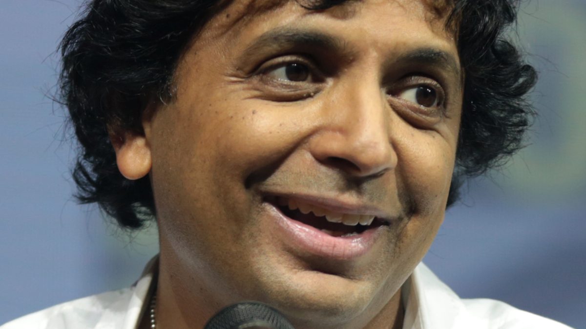 M. Night Shyamalan smiling as he speaks into a microphone