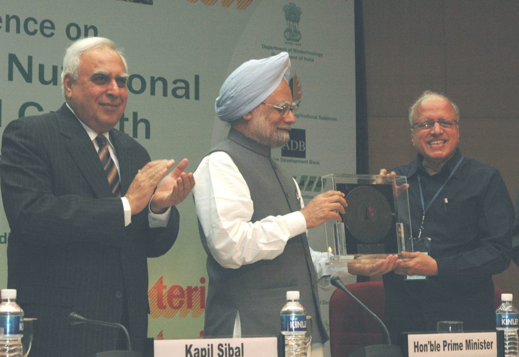 M. S. Swaminathan in glasses and a suit receiving an award from Prime Minister Manmohan Singh