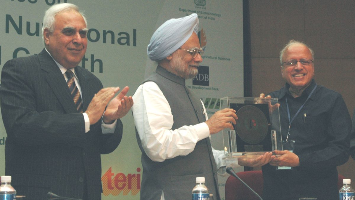 M. S. Swaminathan in glasses and a suit receiving an award from Prime Minister Manmohan Singh