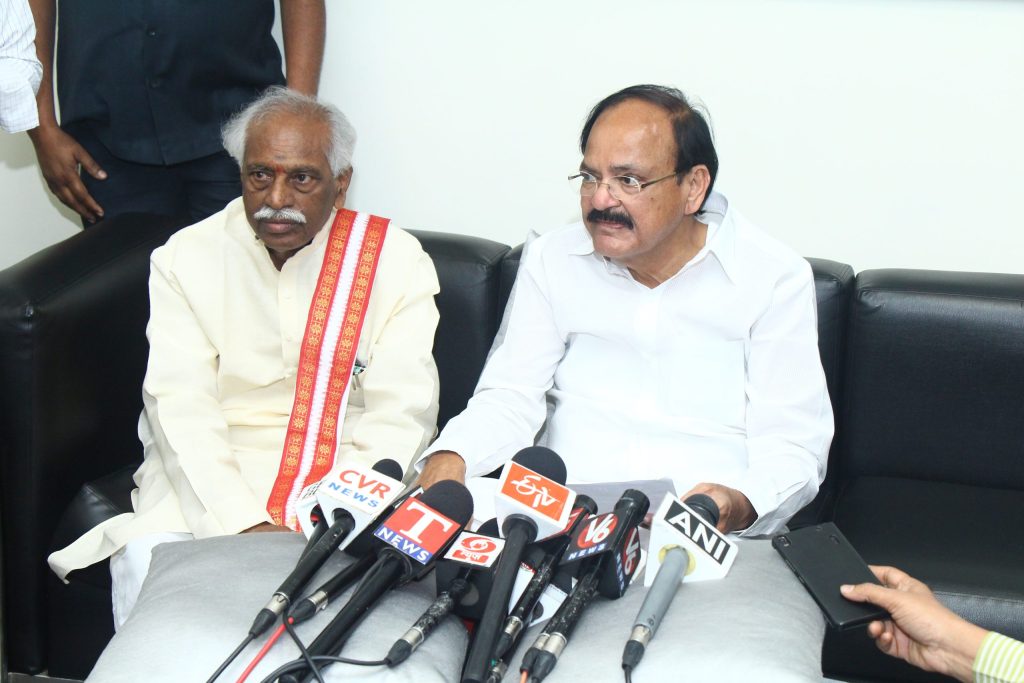 M. Venkaiah Naidu in a white shirt and dhoti seated beside Bandaru Dattatreya at a press interaction