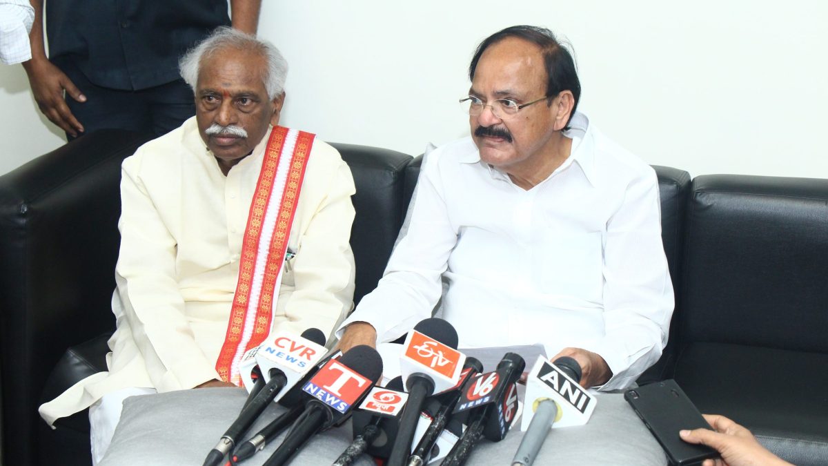 M. Venkaiah Naidu in a white shirt and dhoti seated beside Bandaru Dattatreya at a press interaction