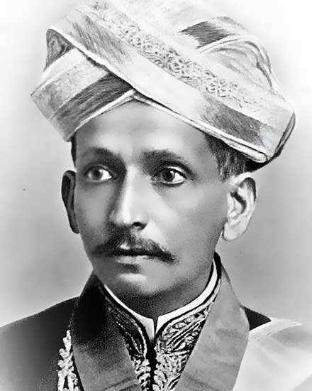 A black-and-white portrait of a young M. Visvesvaraya in a turban and embroidered coat
