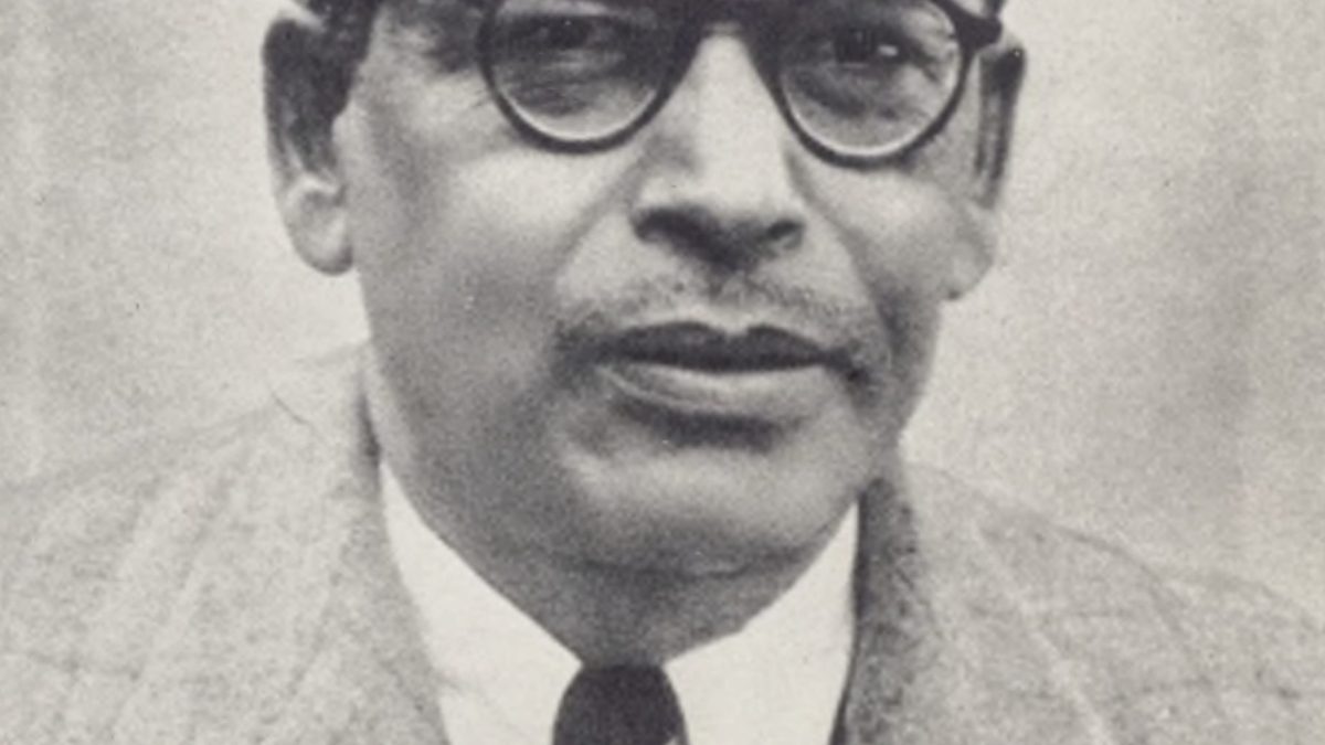 Black-and-white portrait of Meghnad Saha in dark-rimmed glasses, a suit and tie