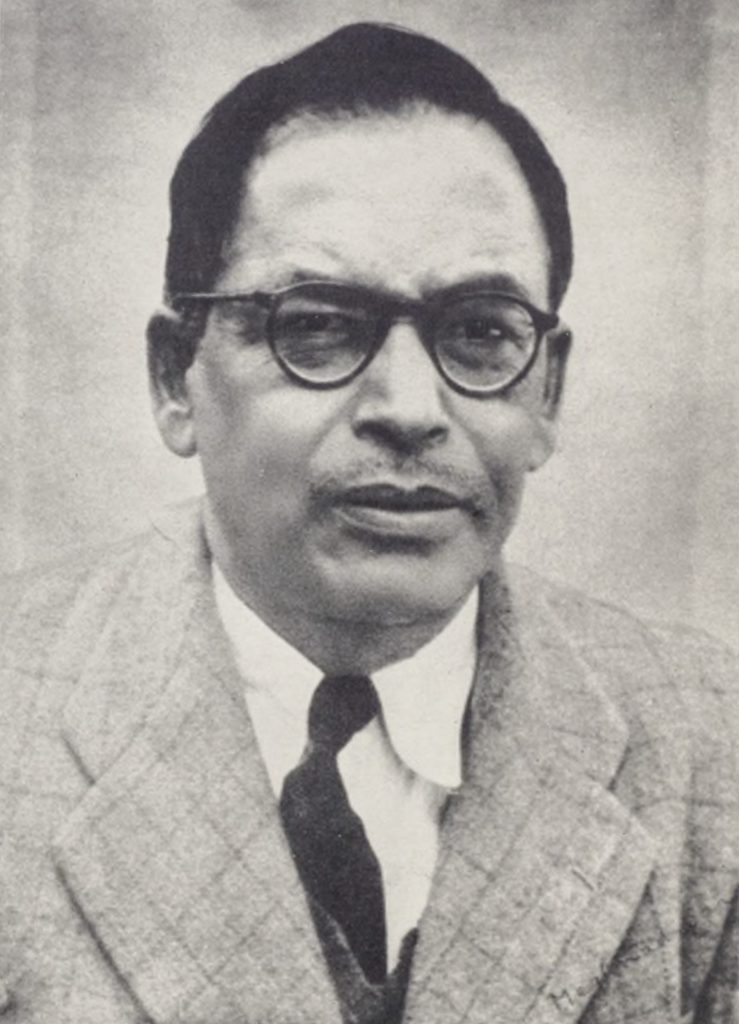 Black-and-white portrait of Meghnad Saha in dark-rimmed glasses, a suit and tie