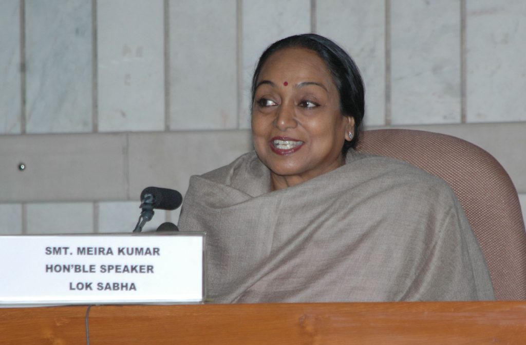 Meira Kumar in a cream sari smiling at a press conference