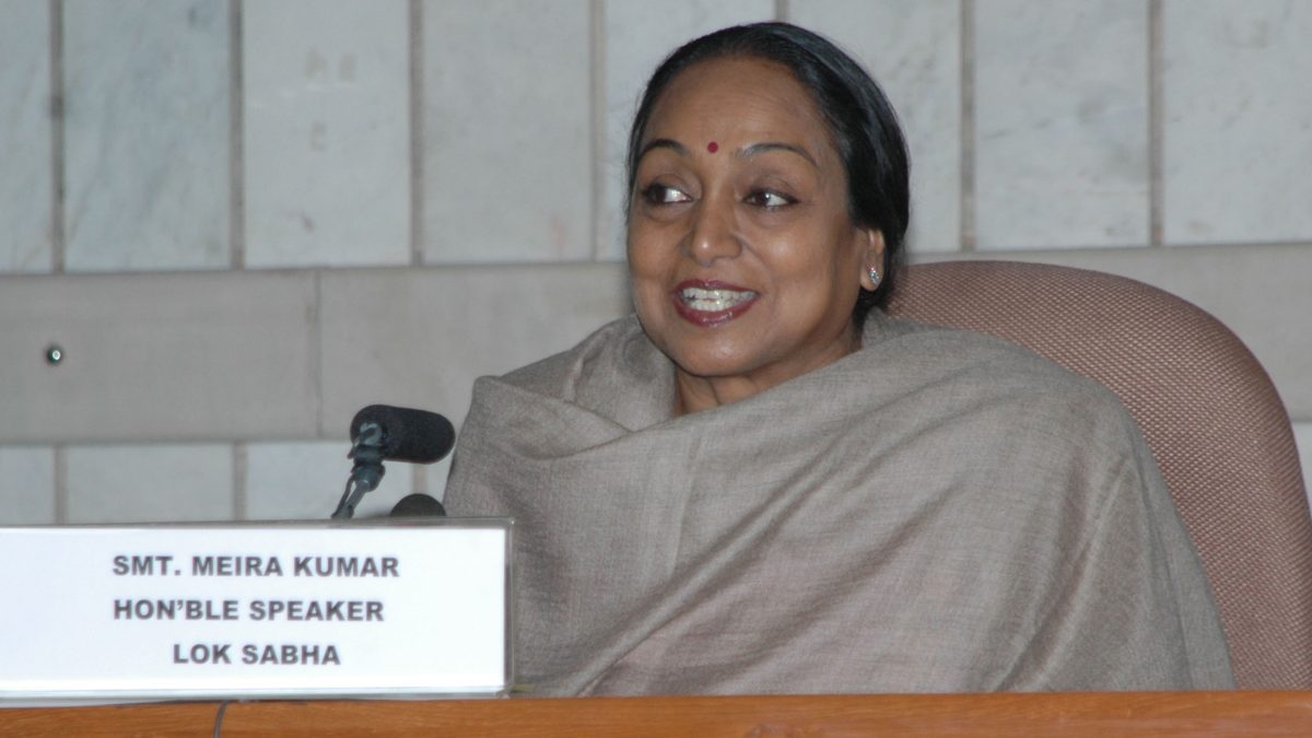 Meira Kumar in a cream sari smiling at a press conference