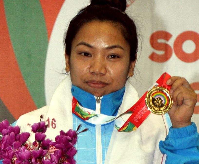 Mirabai Chanu holding a gold medal and a bouquet