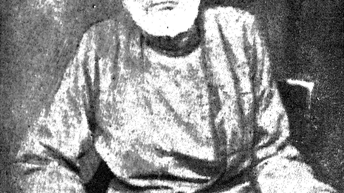An old photograph of Mirza Ghalib seated, in a tall cap