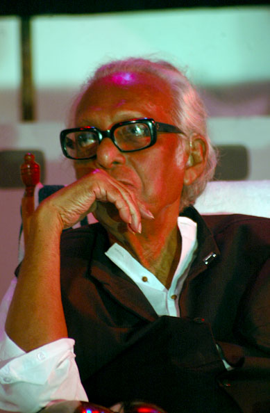 Mrinal Sen in glasses, seated with his hand to his chin