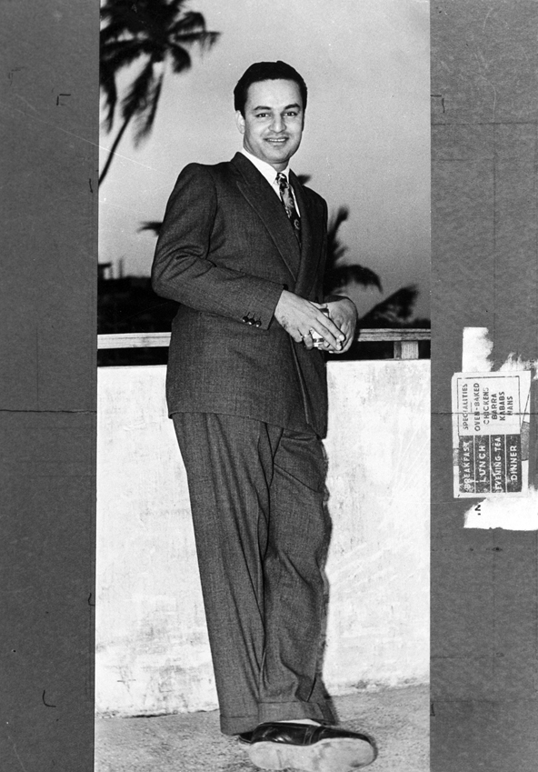 A black-and-white photograph of the singer Mukesh standing in a suit