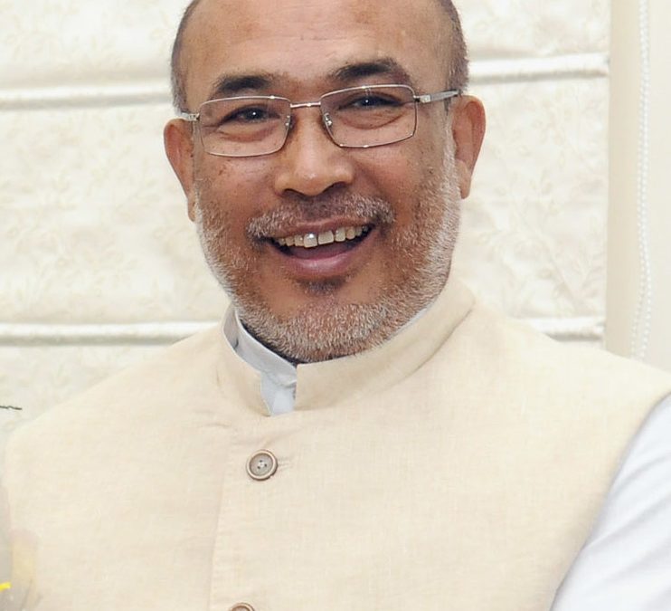 N. Biren Singh in glasses and a cream waistcoat, smiling