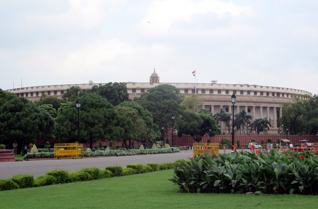 The circular old Parliament House building in New Delhi with lawns in front