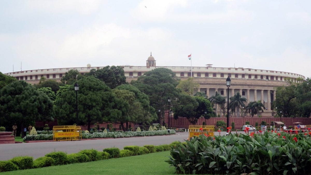 The circular old Parliament House building in New Delhi with lawns in front