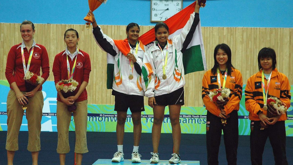Two Indian badminton players on court after winning a doubles medal