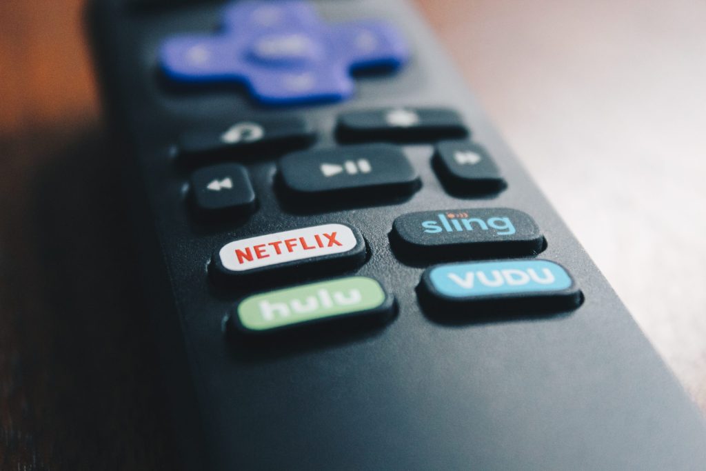 A TV remote control with a Netflix button
