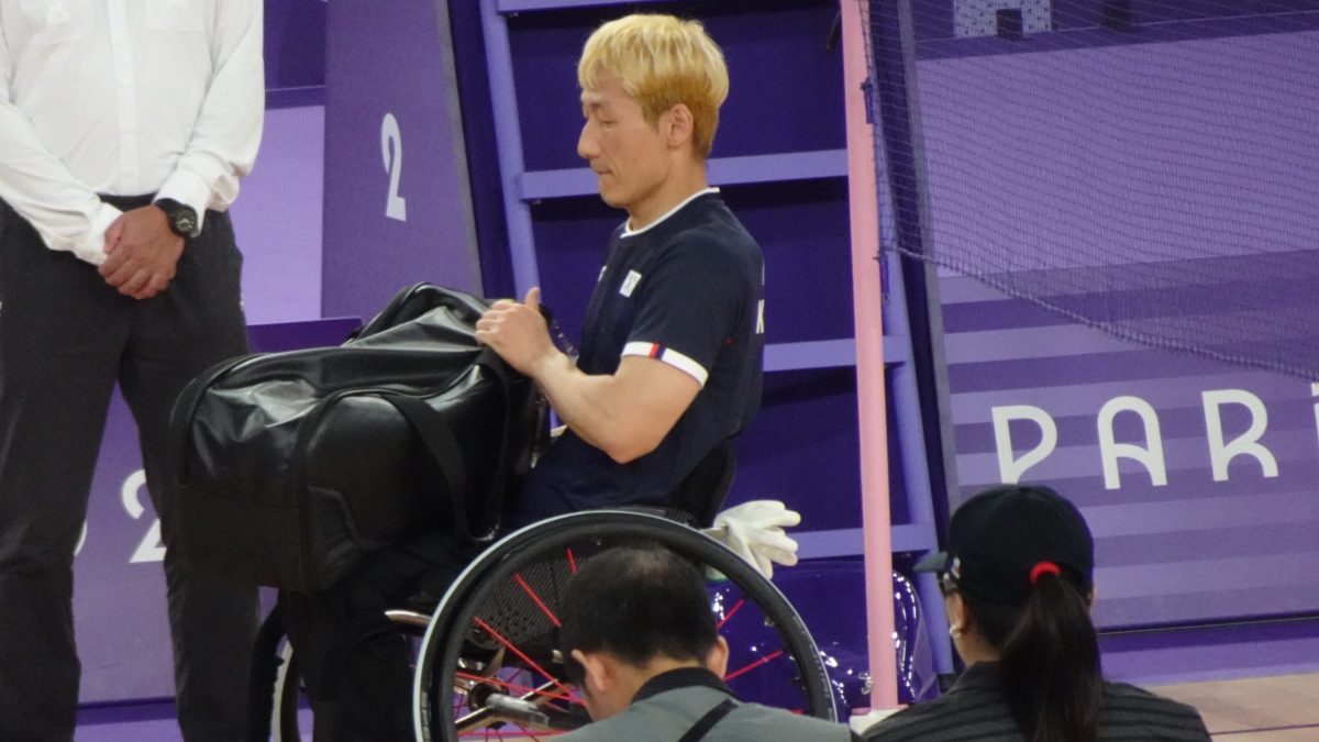 A para badminton player in a wheelchair on court