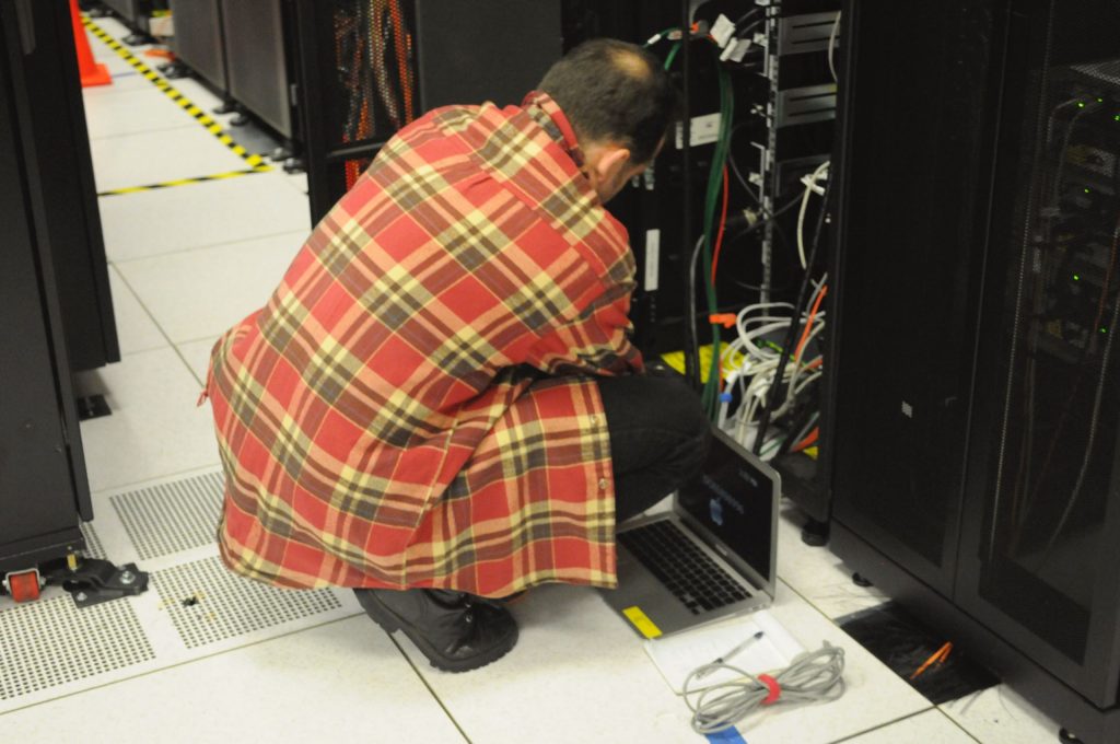 A technician working on a server rack