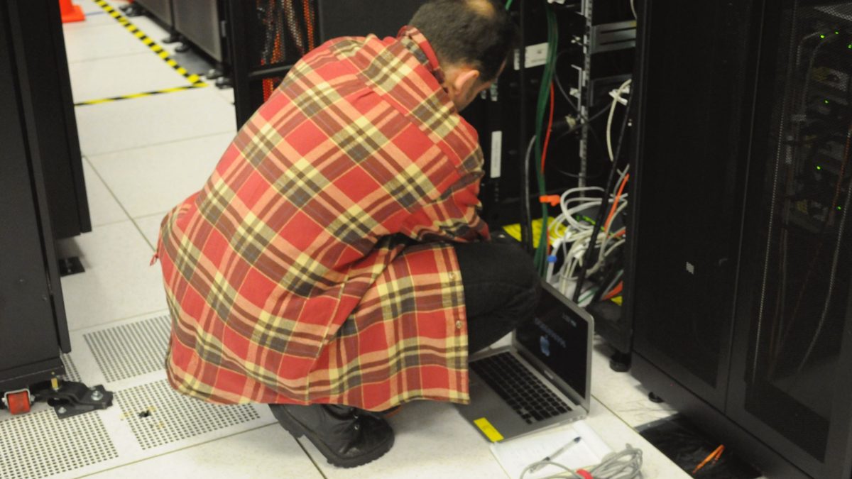 A technician working on a server rack