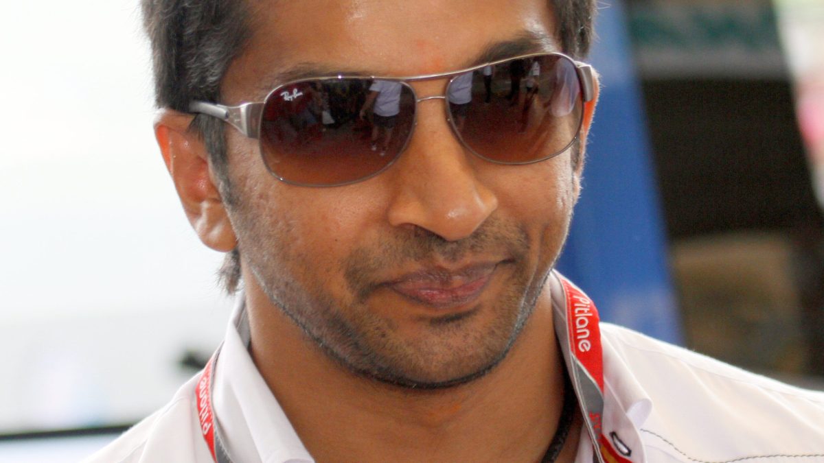 Narain Karthikeyan in sunglasses and a white team shirt