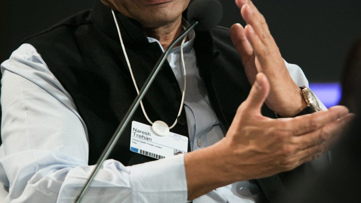 Naresh Trehan in a dark suit speaking at a conference