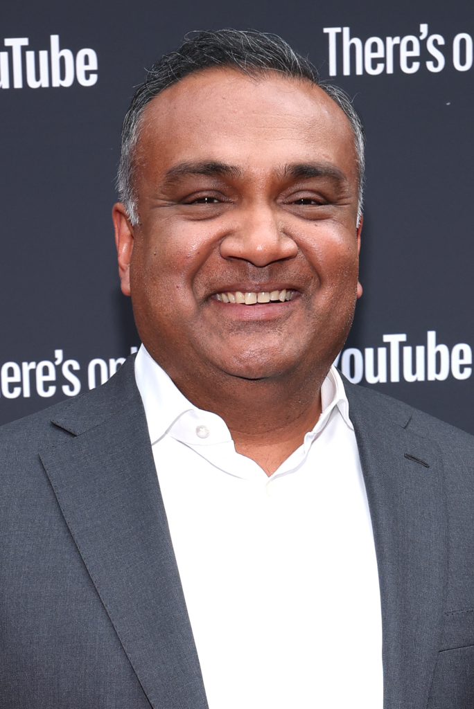 Neal Mohan in a dark jacket speaking on stage