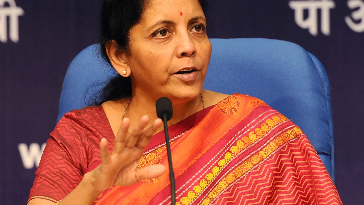 Nirmala Sitharaman speaking into a microphone at a press conference in New Delhi