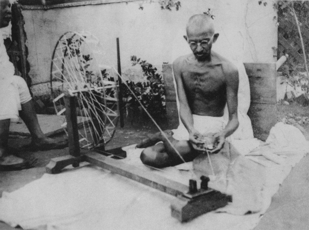 Mahatma Gandhi spinning cotton on a charkha