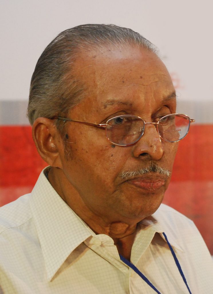 O. N. V. Kurup in glasses and a cream shirt, looking to one side