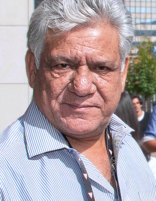 Om Puri with grey hair, in a pale shirt, at a film festival