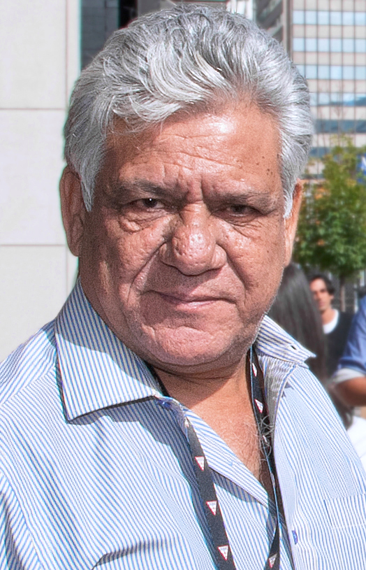 Om Puri with grey hair, in a pale shirt, at a film festival