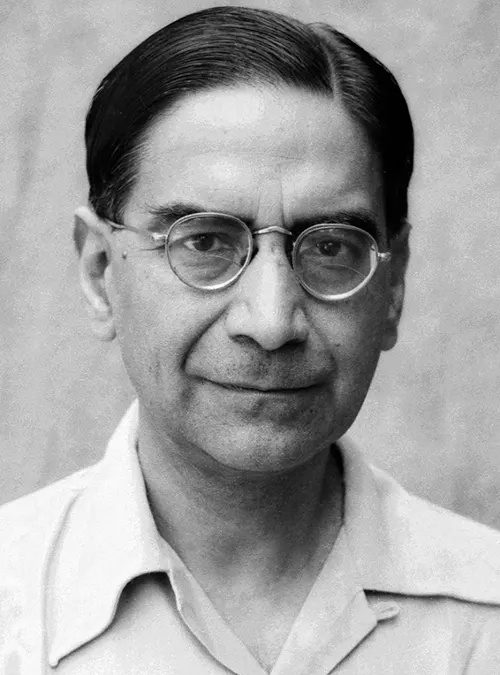 A black-and-white portrait of P. C. Mahalanobis in round glasses and an open-necked shirt