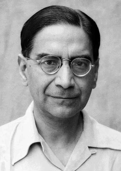A black-and-white portrait of P. C. Mahalanobis in round glasses and an open-necked shirt