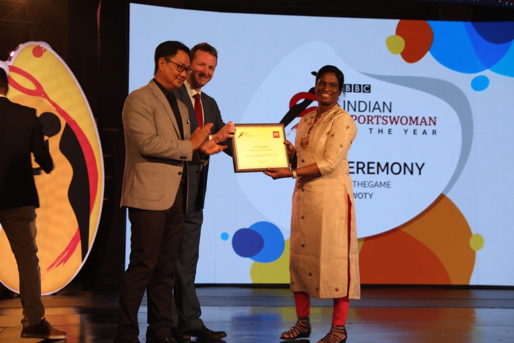 P. T. Usha in a sari receiving an award on a stage