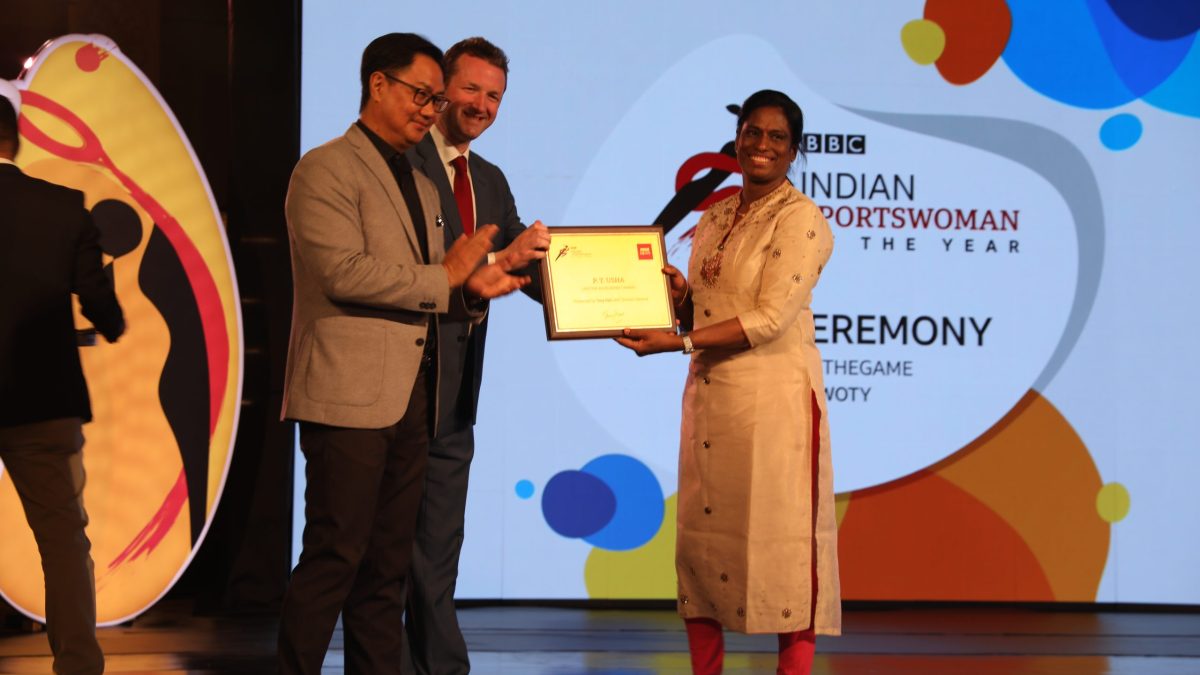 P. T. Usha in a sari receiving an award on a stage