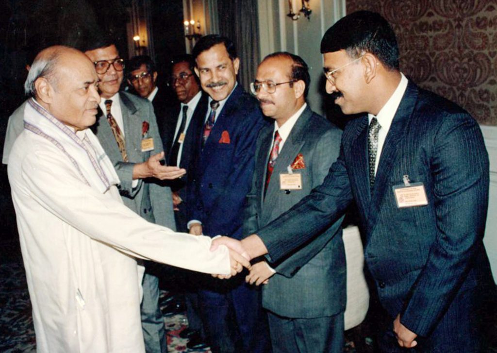 P. V. Narasimha Rao in a white kurta shaking hands with a delegate in a receiving line