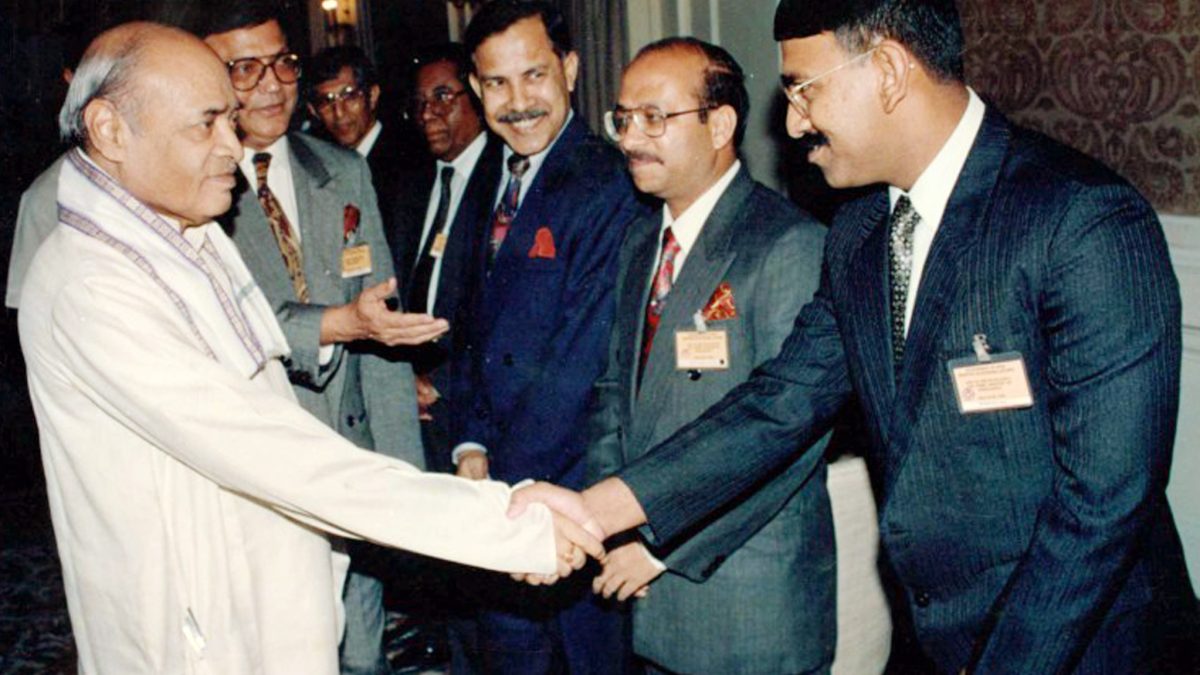 P. V. Narasimha Rao in a white kurta shaking hands with a delegate in a receiving line