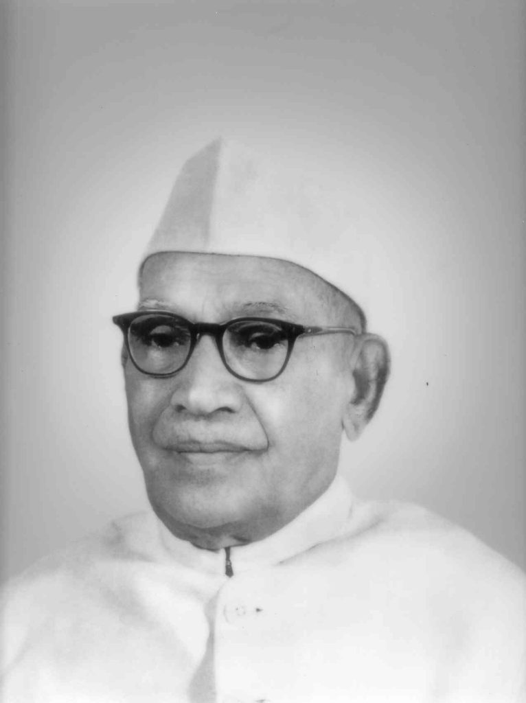 Black-and-white portrait of Pattom Thanu Pillai in a white cap, dark glasses and white jacket