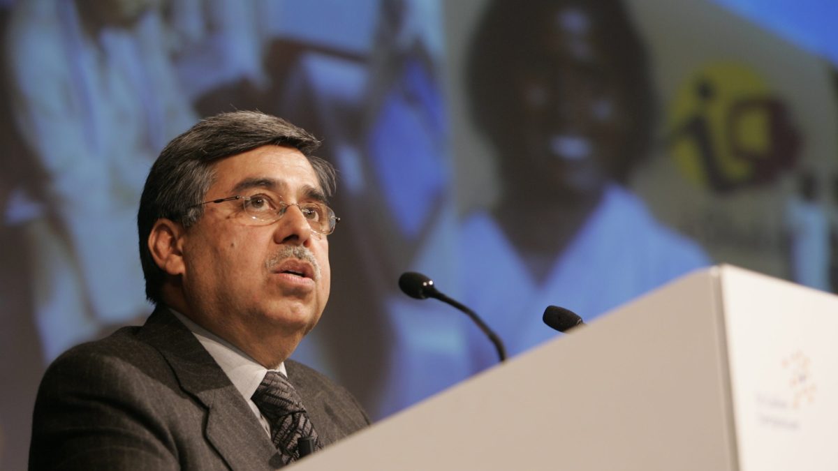 Pawan Munjal in glasses and a dark suit speaking at a lectern