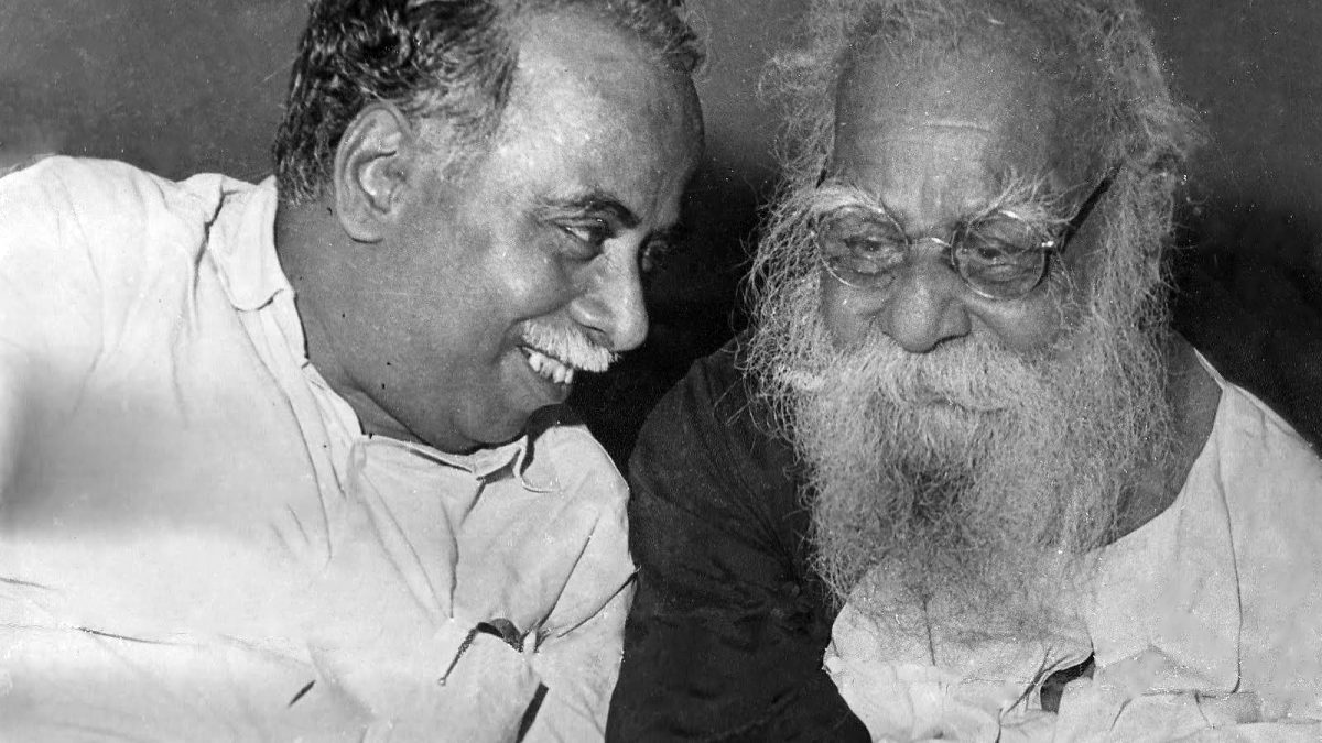 Black-and-white photograph of the white-bearded Periyar, right, in conversation with C. N. Annadurai
