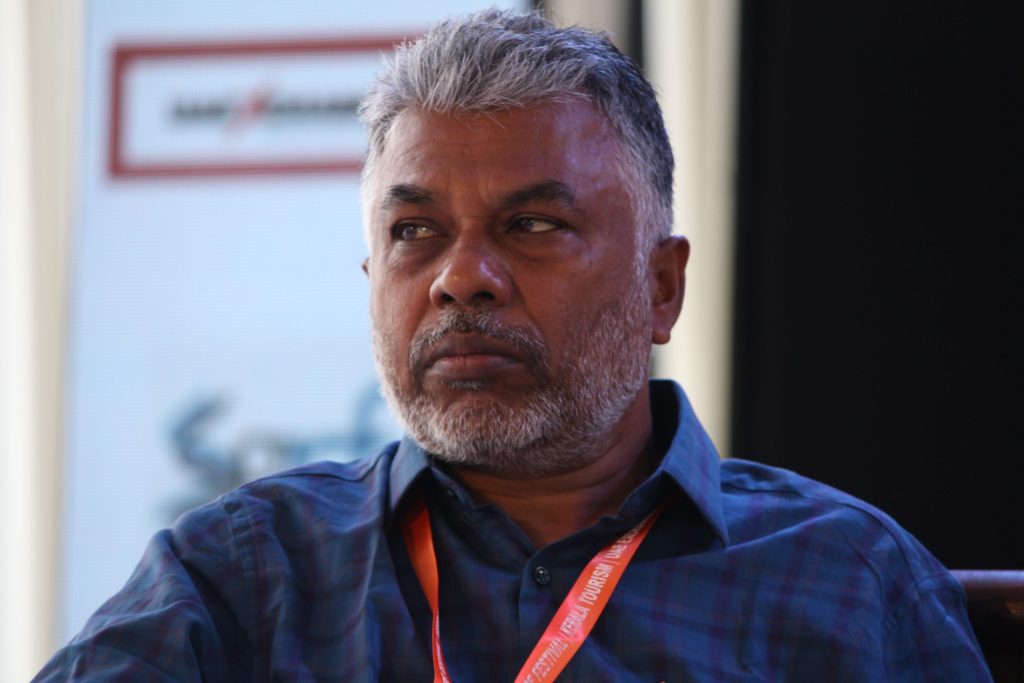 Perumal Murugan with grey hair in a blue checked shirt at a literature festival