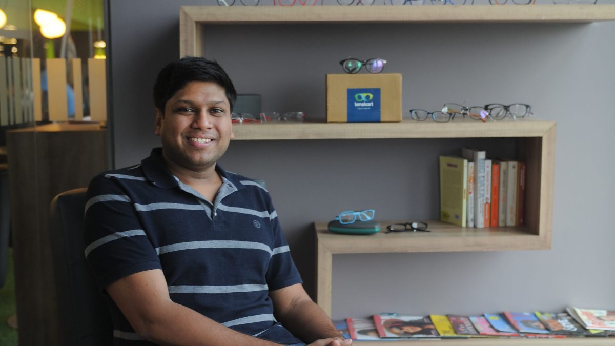 Peyush Bansal in a striped polo shirt seated in an office, smiling