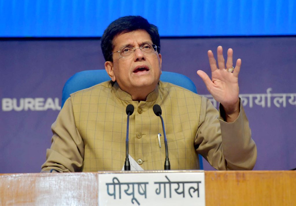Piyush Goyal in a brown jacket gesturing as he speaks at a press briefing