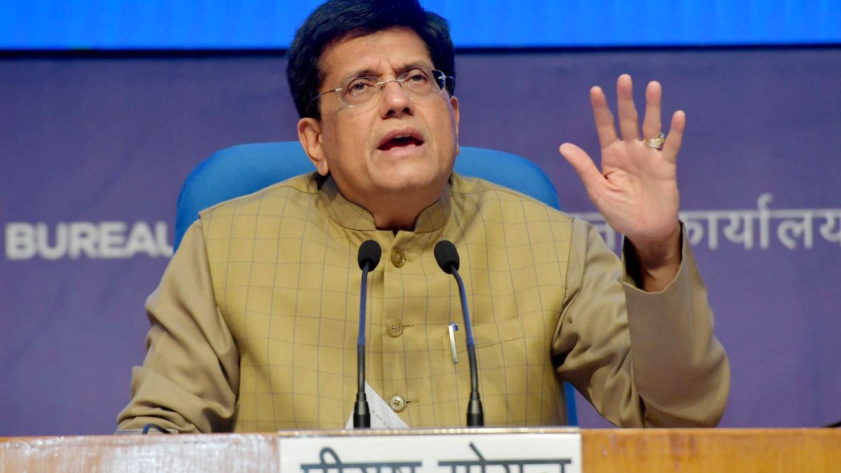 Piyush Goyal in a brown jacket gesturing as he speaks at a press briefing