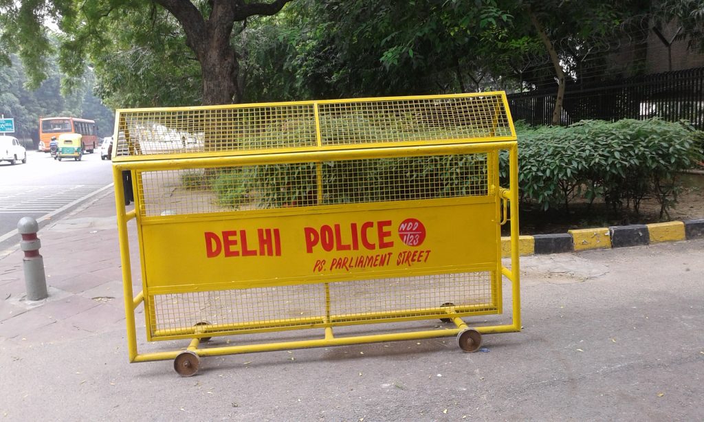 A yellow Delhi Police barricade on a street in New Delhi