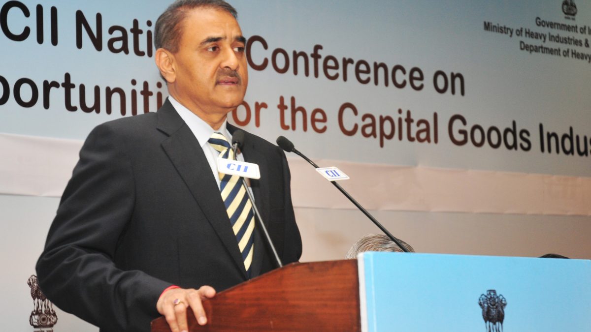 Praful Patel in a dark suit and striped tie speaking at a lectern