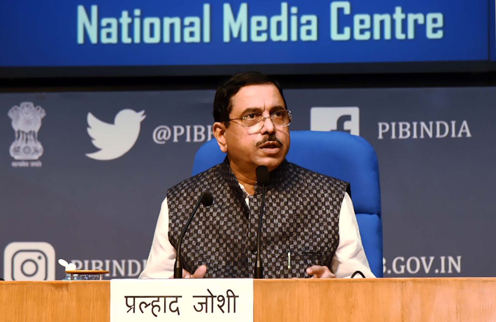 Pralhad Joshi in glasses and a patterned waistcoat seated at a press conference at the National Media Centre