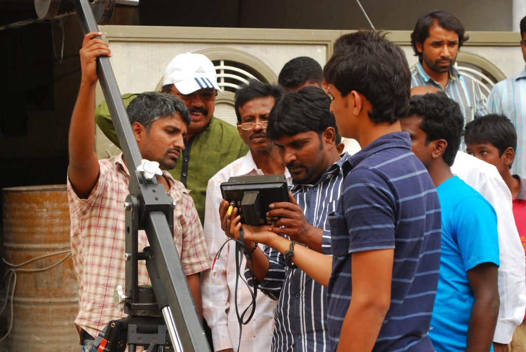 A film crew gathered around a camera during a shoot in Karnataka