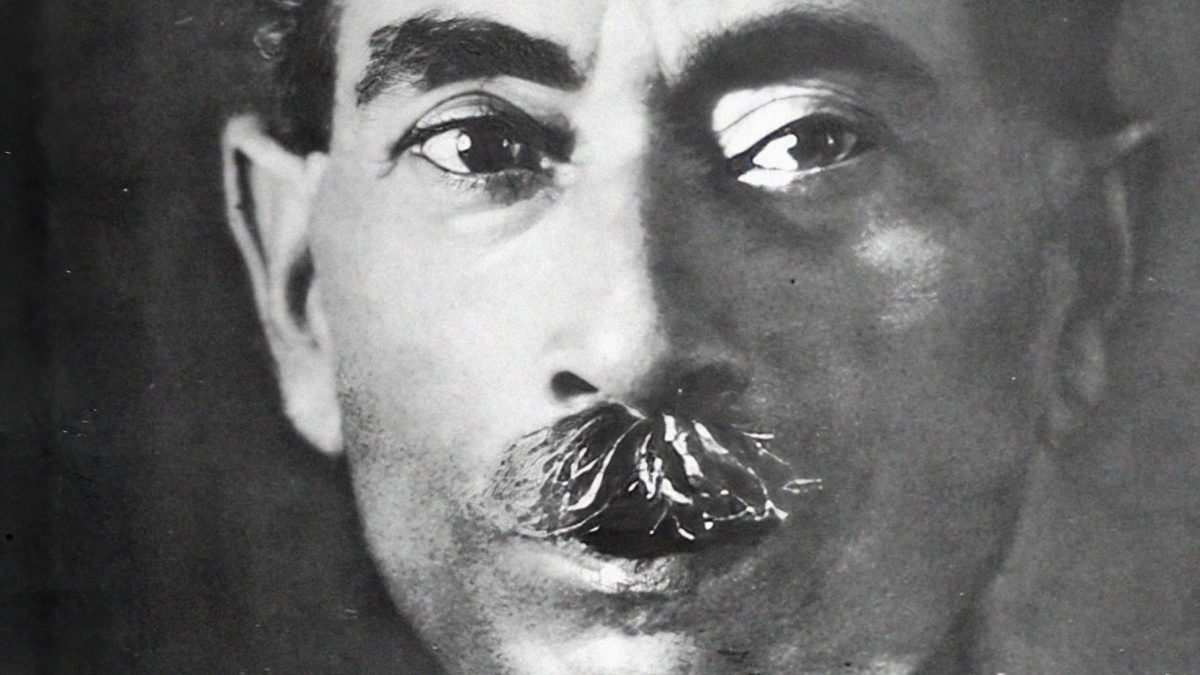 Black-and-white portrait of Premchand with a thick moustache, in a white kurta